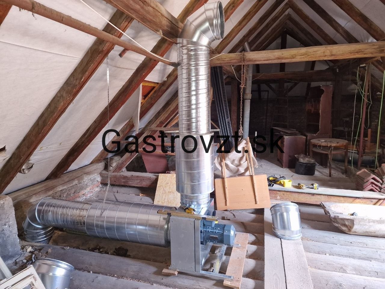 Odsávací ventilátor a potrubie v podkroví budovy