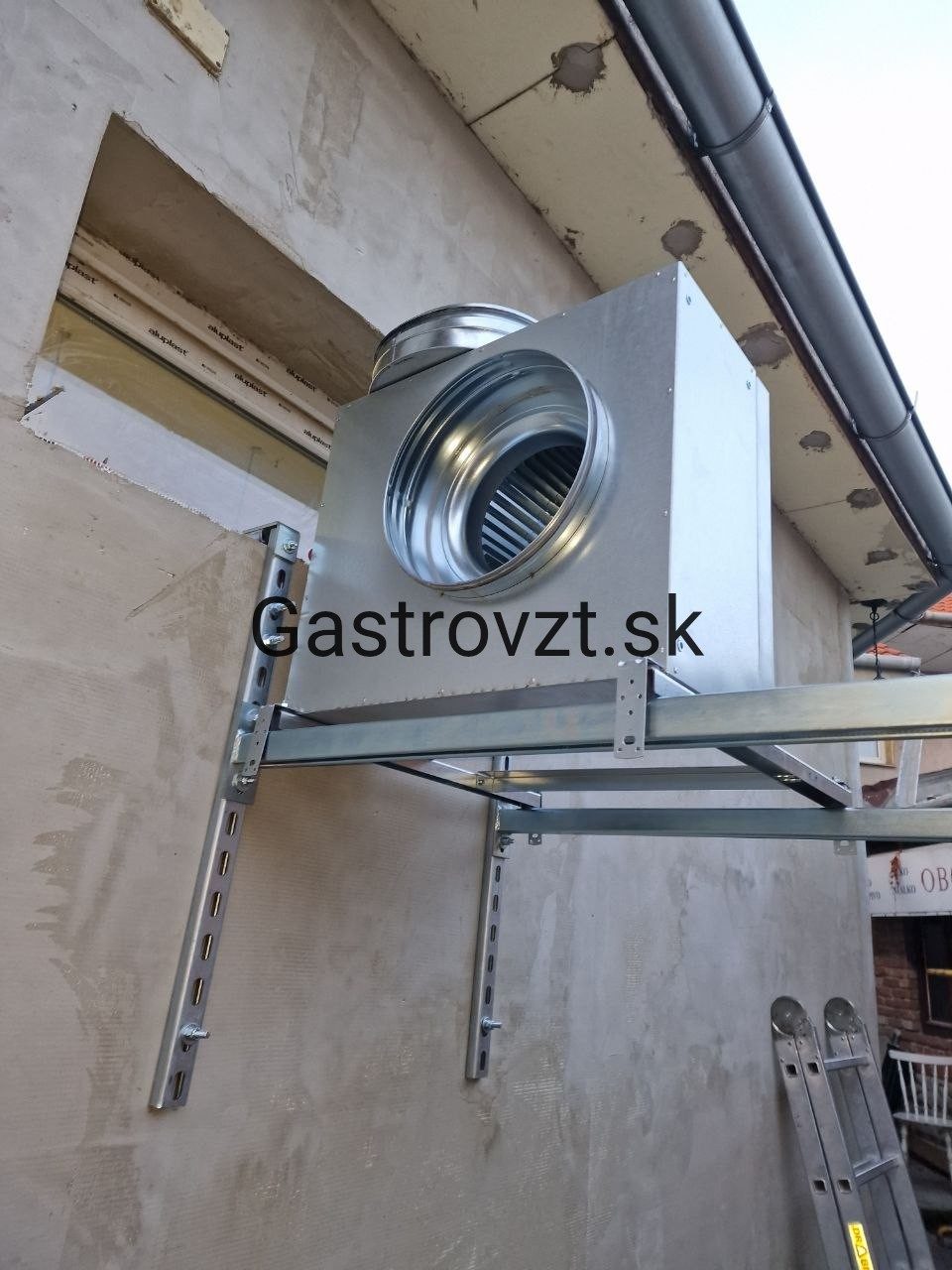 Odsávací ventilátor na konzolách na fasáde budovy
