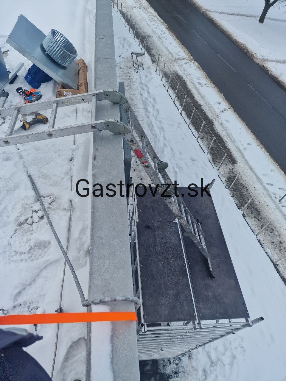 Kuchynský ventilátor a lešenie na streche počas montáže v zime