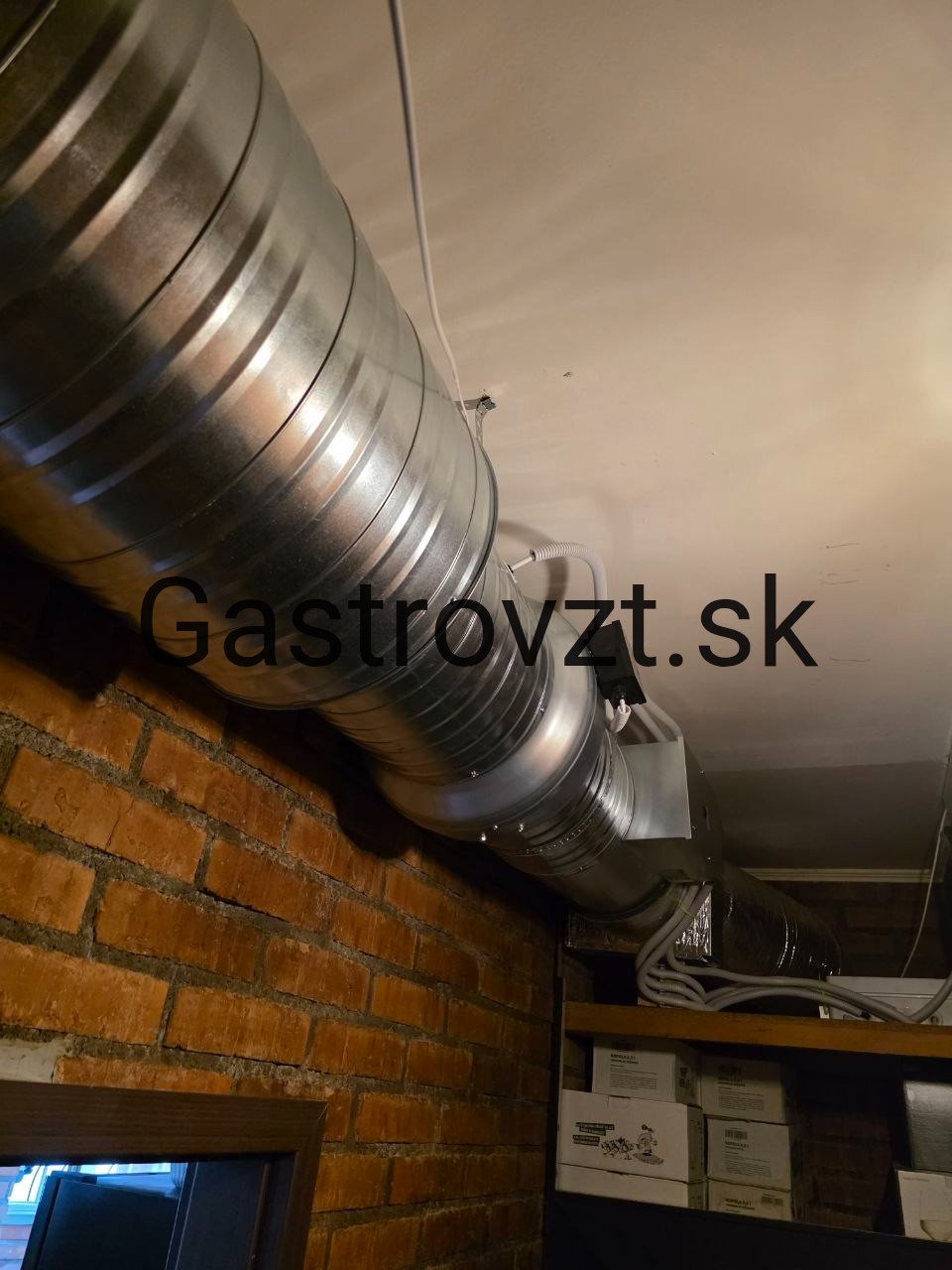 Potrubie vedené popri tehlovej stene jedálne