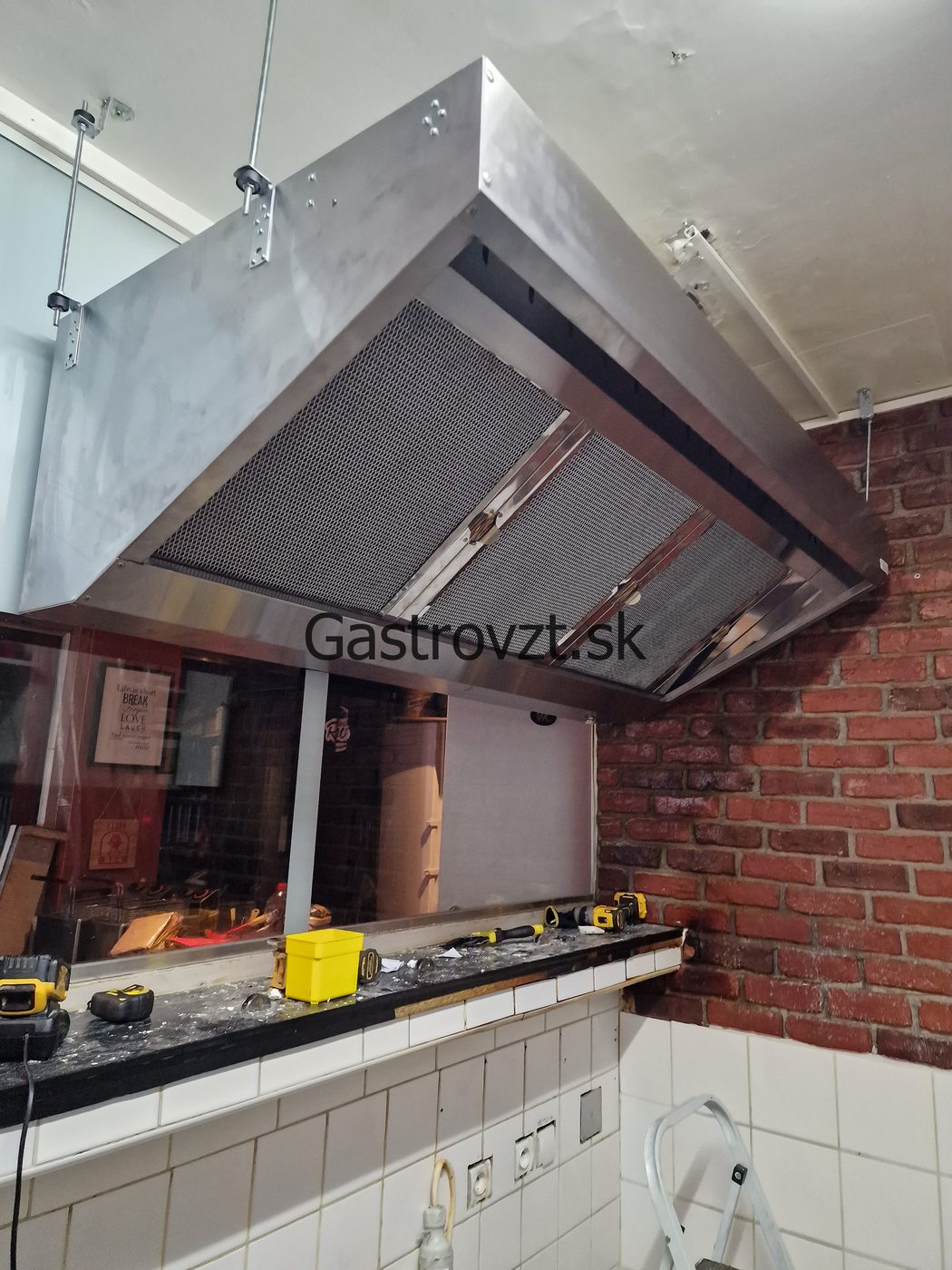 Nerezový prístenný digestor nad grilom v reštauračnej kuchyni
